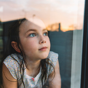 a little girl looking out of a window.