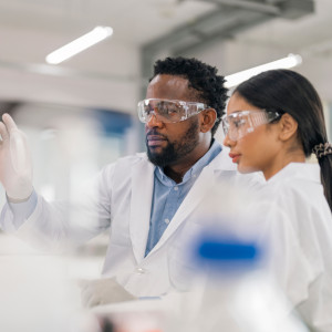 a man and woman in lab coats looking at something.