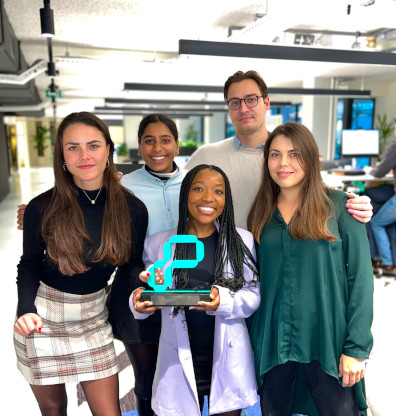 a group of people standing next to each other in an office holding an award